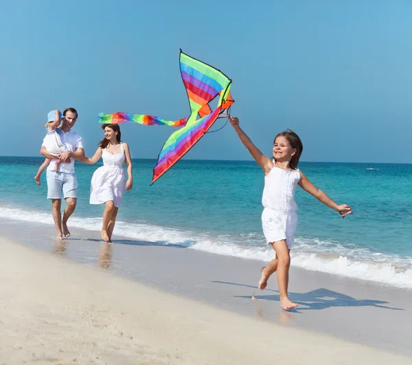 Feliz familia joven con volar una cometa —  Fotos de Stock