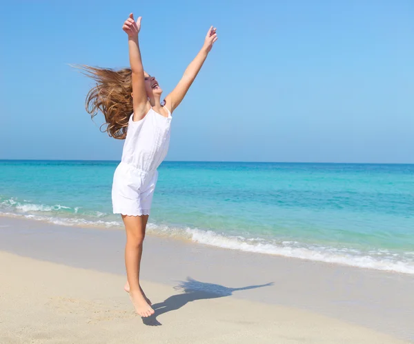 Cute little girl jumping on the beach — Stock Photo, Image