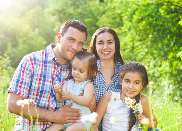 Jovem família feliz com crianças na floresta de primavera — Fotografia de Stock