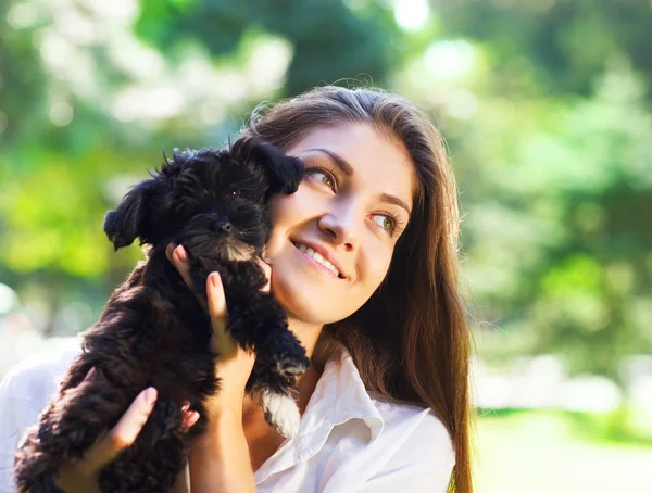 Young brunette woman hugging her lap dog puppy — Stock Photo, Image