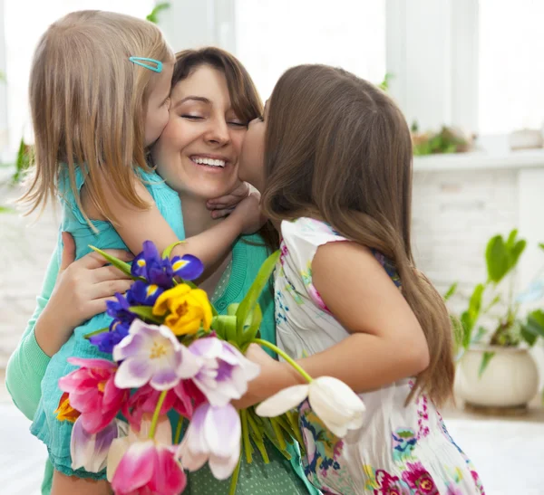 Gelukkige vrouw en haar kleine dochters in de woonkamer Stockfoto