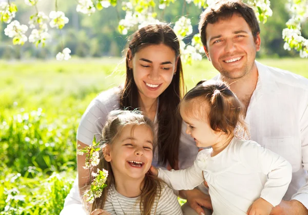 Glückliche junge Familie mit zwei Kindern im Freien — Stockfoto