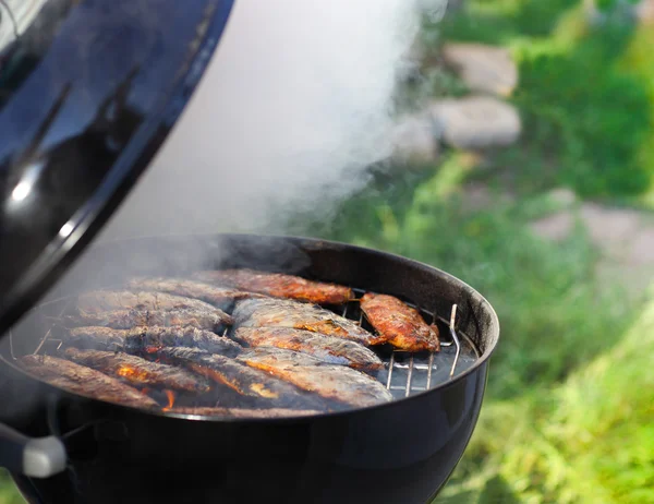 Fiskfiléer på grillen med flames — Stockfoto