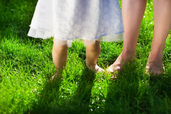 Bambina prendendo i primi passi con l'aiuto della madre — Foto Stock