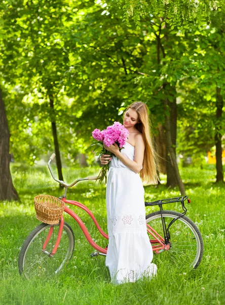 Mooie blonde vrouw dragen een mooie jurk met plezier in park wi — Stockfoto