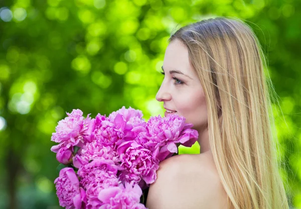 Vacker blond med pion blommor — Stockfoto