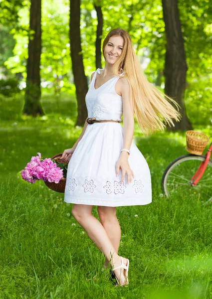 Mulher loira bonita vestindo um vestido agradável se divertindo no parque wi — Fotografia de Stock