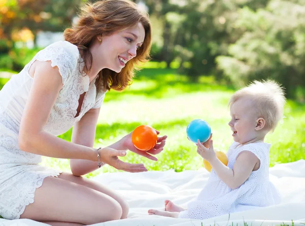 幸せな母と彼女の子供が公園で一緒に遊んでいます。 — Stockfoto