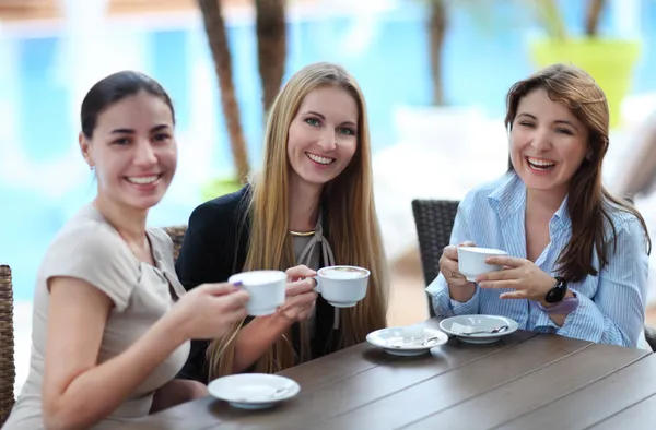 Unga kvinnor dricker kaffe på kafé utomhus — Stockfoto