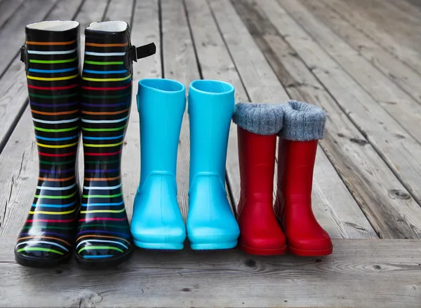 Üç çift renkli yağmur botları — Stok fotoğraf