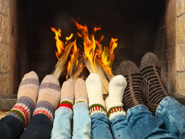 气候变暖靠近壁炉的脚 免版税图库图片
