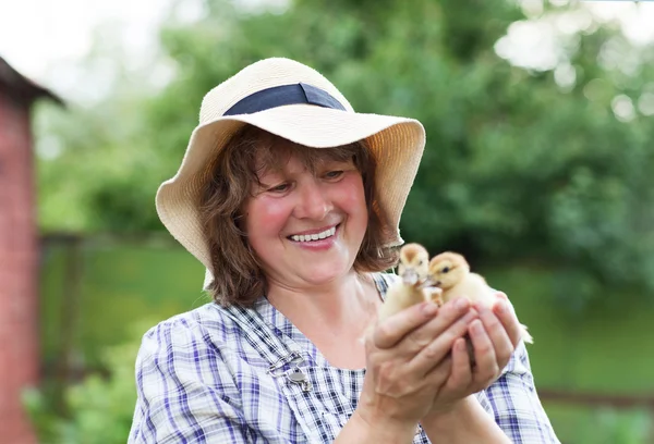 Mujer de mediana edad con patitos amarillos —  Fotos de Stock