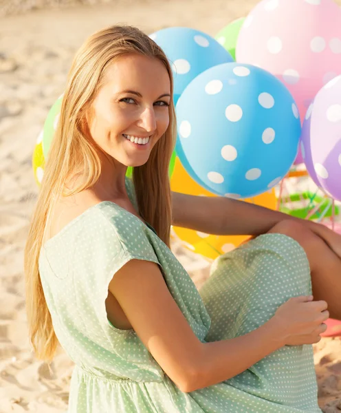 Donna sulla spiaggia con palloncini a pois colorati — Foto Stock