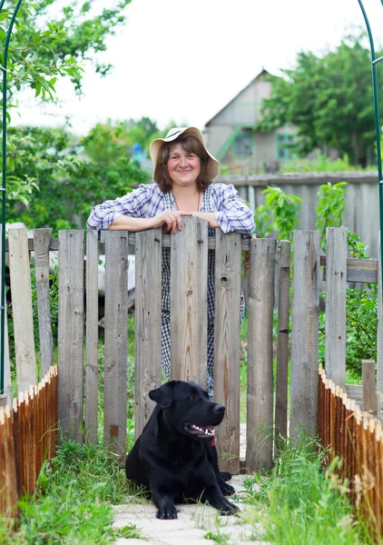 Happy woman in the garden with her labrador — Stock Photo, Image
