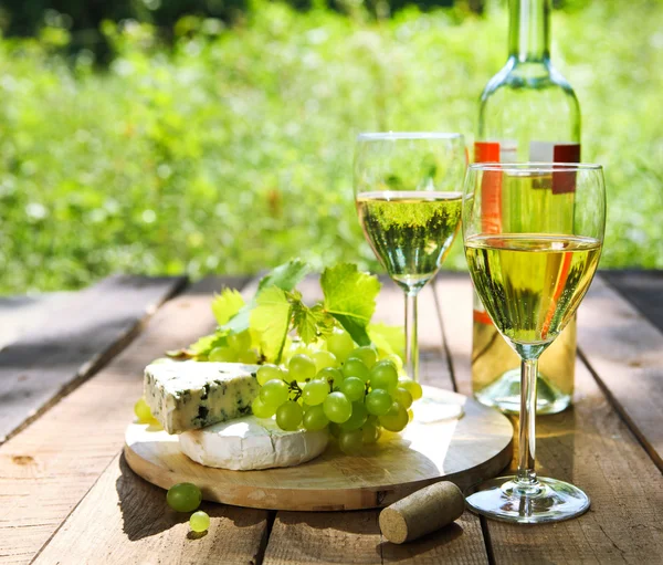 Queso, uvas y dos copas de vino blanco — Foto de Stock