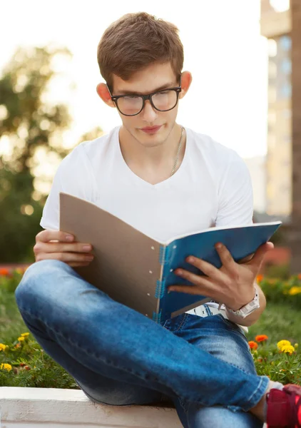 Estudante lendo seu caderno — Fotografia de Stock