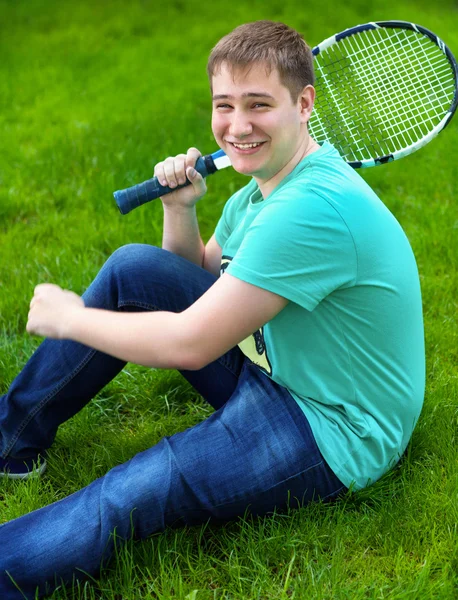 Tenis raketi tutarken gülümseyen genç çocuk — Stok fotoğraf
