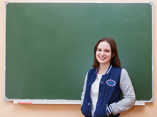 Estudiante chica de pie cerca de pizarra — Foto de Stock