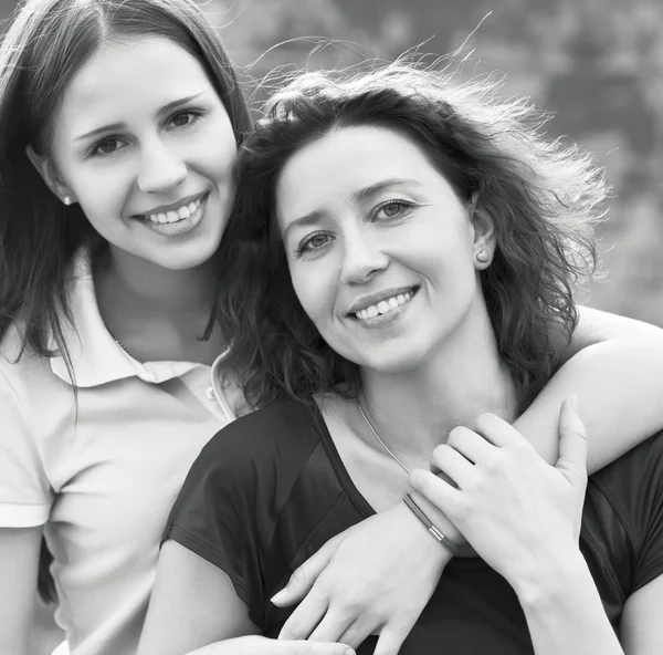 Joven mujer sonriente con su hija adolescente al aire libre —  Fotos de Stock