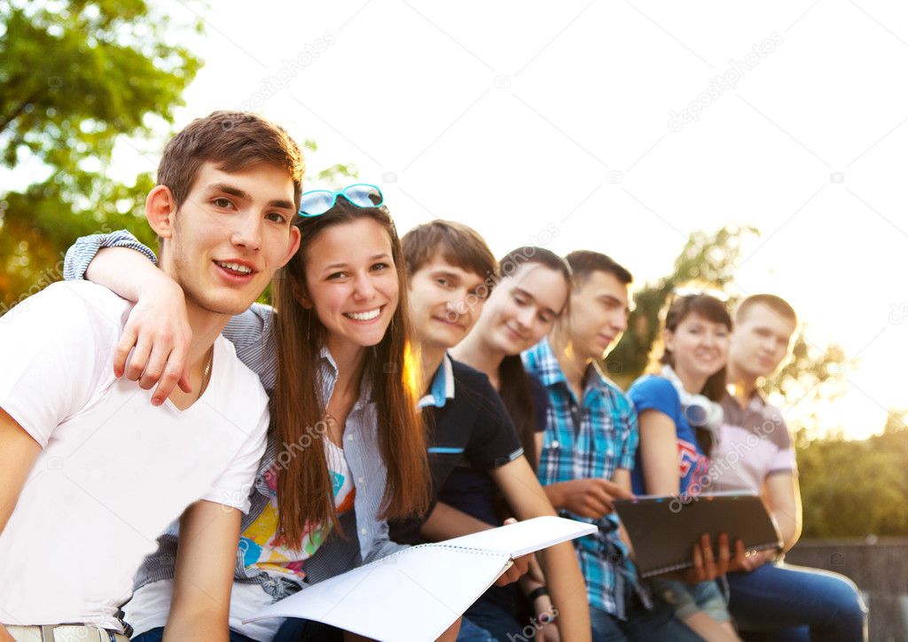 Group of students or teenagers with notebooks outdoors 