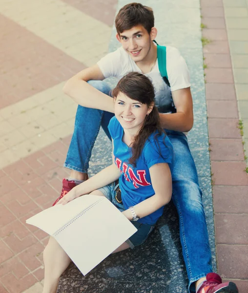 Два студента или подростка с блокнотами на улице — стоковое фото