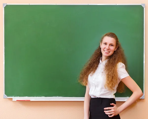 Estudiante chica de pie cerca de pizarra — Foto de Stock