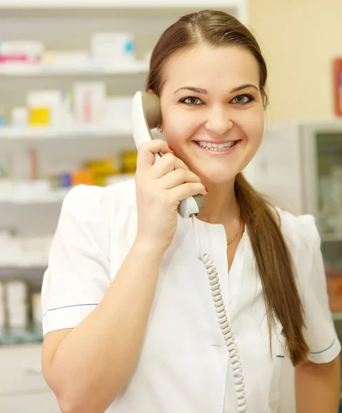 Portret van een glimlachende vrouwelijke apotheker op de telefoon — Stockfoto