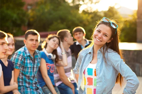 Kvinnlig leende student utomhus med vänner — Stockfoto