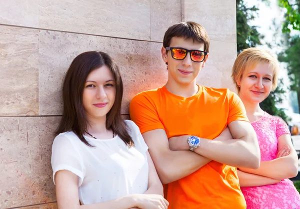 Group of smiling teenagers sitting outdoors — Stock Photo, Image