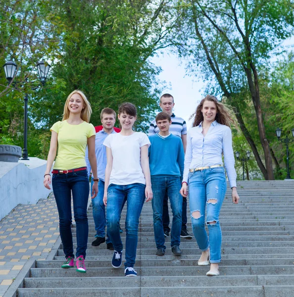 Groupe d'adolescents souriants marchant à l'extérieur — Photo