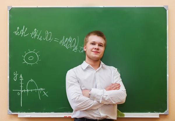 Student standing near the blackboard in the classroom — Stock Photo, Image