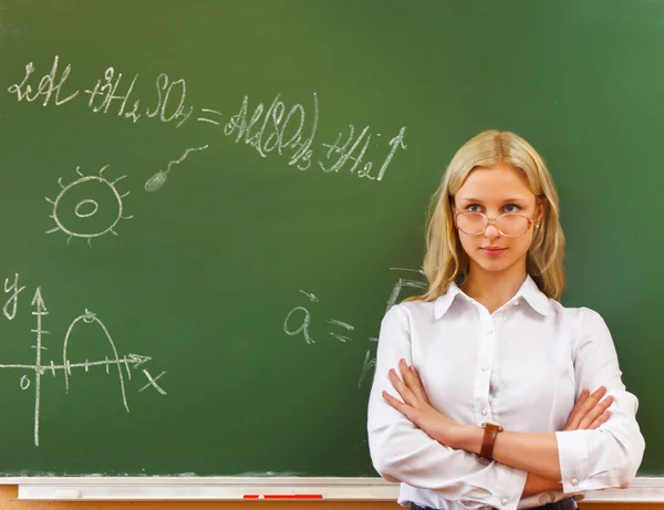 Schülerin steht neben Tafel im Klassenzimmer — Stockfoto