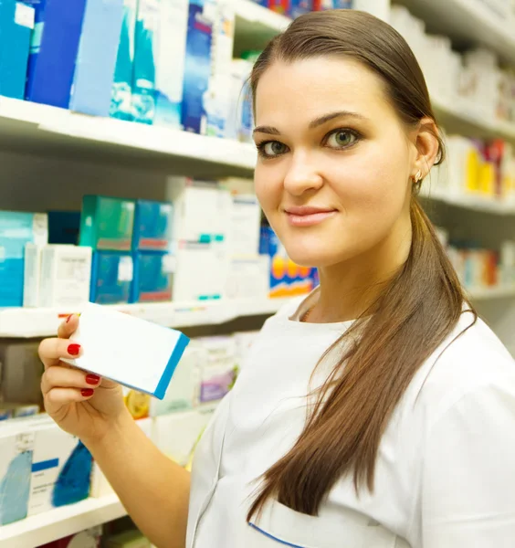 Pharmacist showing medicine box at pharmacy counter — Stock Photo, Image