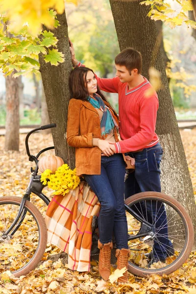 Casal feliz com andar de bicicleta no parque de outono — Fotografia de Stock