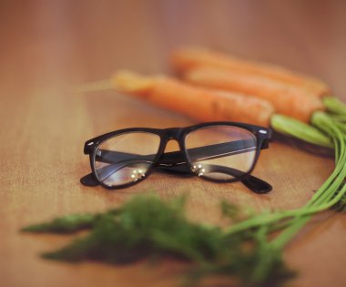 Glasses next to a carrot  clipart