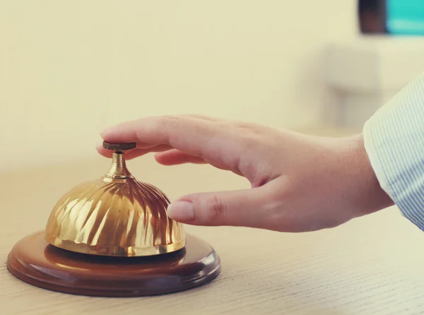 Hand av en kvinna med en hotel bell — Stockfoto