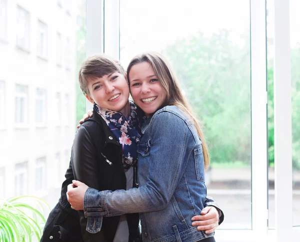 Two happy female students in classroom — Stock Photo, Image