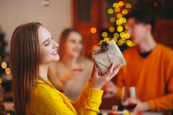 Jovem Dando Presente Embrulhado Amigo Enquanto Sentam Mesa Celebrando Natal — Fotografia de Stock