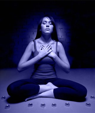 Yoga yapan ve elinde haç tutan çekici genç bir kadın. 2022 'nin rengi, çok canlı, ayak parmaklı.