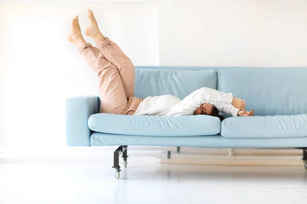 Photo Young Cheerful Woman Casual Clothes Falling Blue Cozy Sofa — 스톡 사진