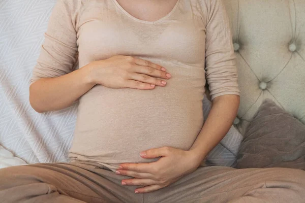 Foto Recortada Mujer Embarazada Sosteniendo Vientre Mientras Relaja Sofá Casa — Foto de Stock