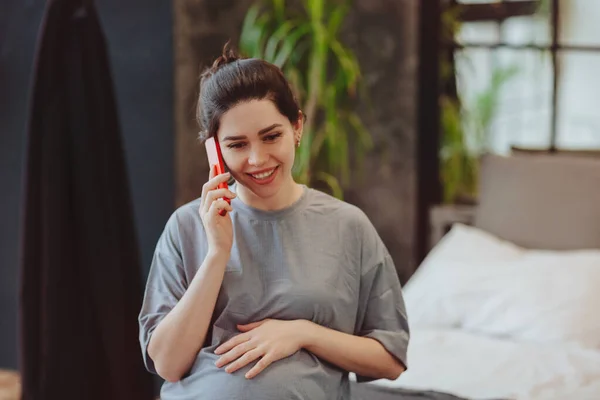 Genç Gülümseyen Karnına Dokunan Hamile Bir Kadın Arkadaşlarıyla Cep Telefonu — Stok fotoğraf