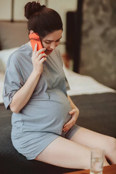 Joven Mujer Embarazada Sonriente Tocando Vientre Hablando Por Teléfono Móvil —  Fotos de Stock
