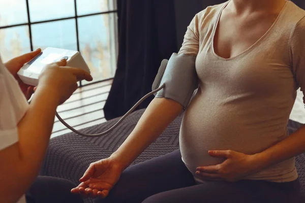 Doctor Measuring Blood Pressure Pregnant Woman While Visiting Her Home — Stock Photo, Image