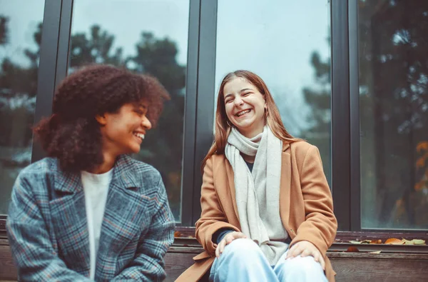 Gelukkig Multiraciale Tienermeisjes Met Afhaalkoffie Zitten Buiten Herfstdag Praten Lachen — Stockfoto
