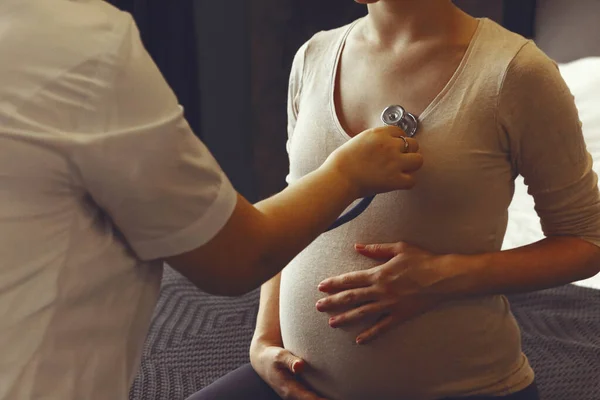 医師は 入院中の妊娠中のケアの約束中に聴診器で妊娠中の女性のハートビートを聞いて クロップドショット 妊娠中の心臓病 妊婦を診察するセラピスト — ストック写真