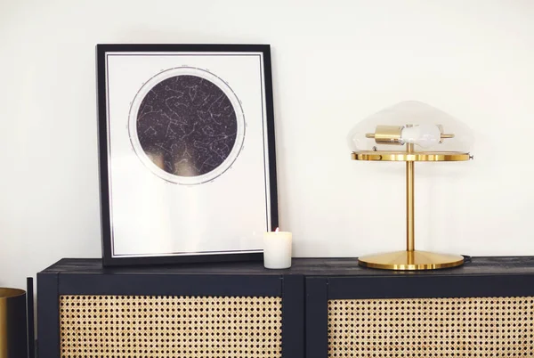 ミニマリストの現代的な部屋のインテリアで光の壁に対して星の地図のポスター ランプとキャンドルを額装した黒い木製のコモードやドレッサー インテリアデザイン要素 家具や家庭用品 — ストック写真