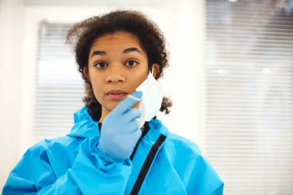 身穿防护服的年轻疲惫的非洲裔美国医务工作者或护士的画像 摘下面具 带着沮丧的表情看着相机 Covid 19大流行病期间的保健工作者 — 图库照片
