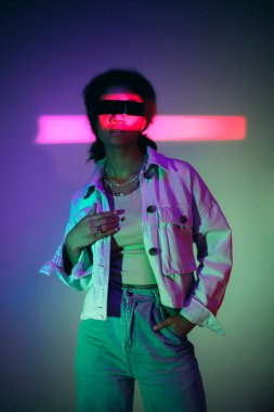 Kendine güvenen Afro-Amerikalı bir kadın sanal dünyayı keşfederken stüdyoda neon ışıklarının altında sanal gerçeklik oyunları oynuyor. Modern teknolojiler