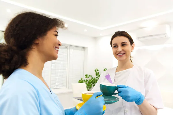 Two Happy Multi Ethnic Female Medical Workers Colleagues Drinking Coffee — Stock Photo, Image